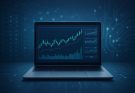 A laptop displaying financial trading charts against a dark blue background